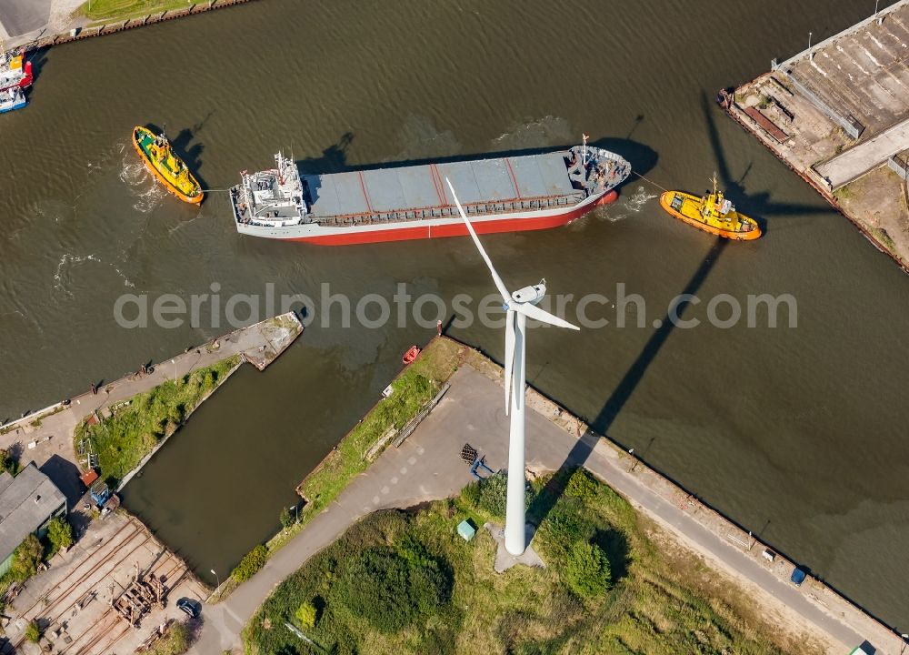 Husum from above - Cargo ship and bulk freighter on the Husumer Au with tugboat help in the port of Husum in the state Schleswig-Holstein, Germany