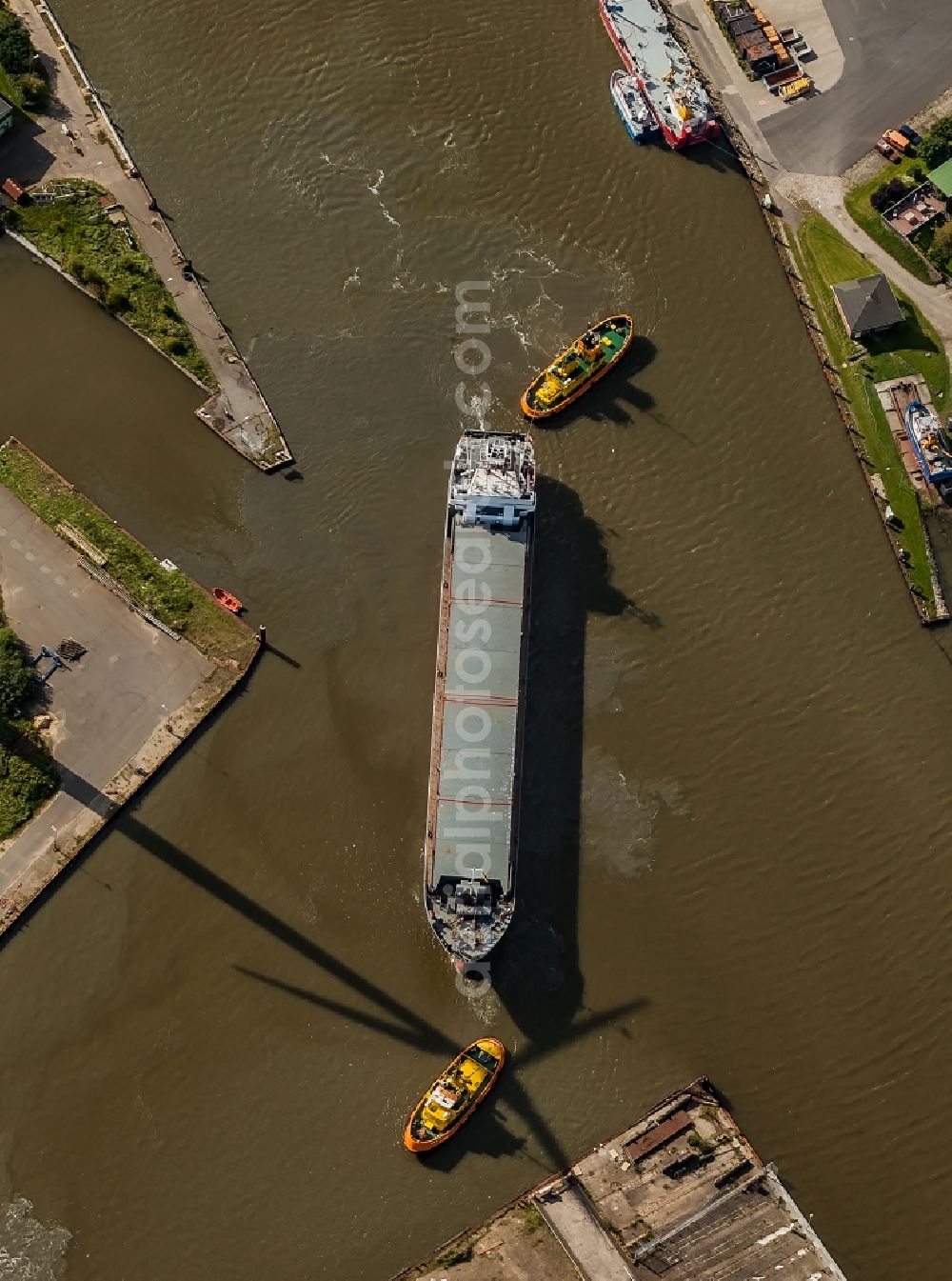 Aerial image Husum - Cargo ship and bulk freighter on the Husumer Au with tugboat help in the port of Husum in the state Schleswig-Holstein, Germany