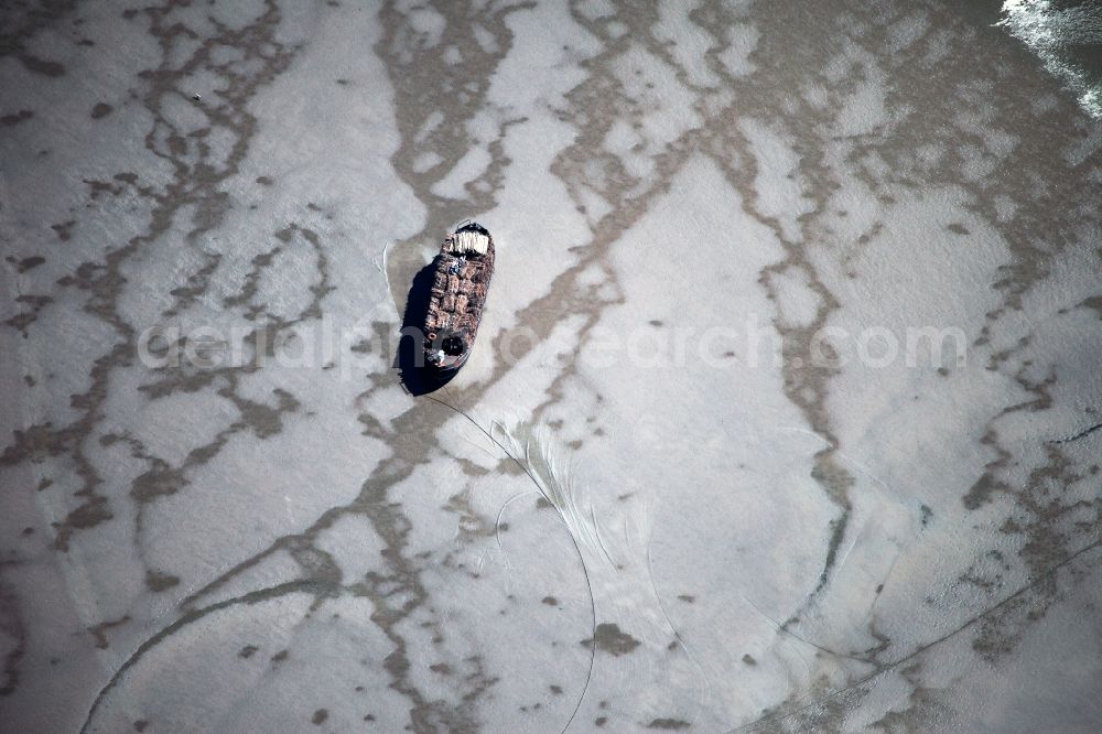 Aerial image Sylt - Freight ship on the south coast of the island Sylt in the state of Schleswig-Holstein. The ship is moving through low tide areas of the South Coast in the North Sea. Surrounded by the Wadden Sea, this part of the island is quite dry during the tide and is part of the national park and nature preserve Schleswig-Holsteinsches Wattenmeer