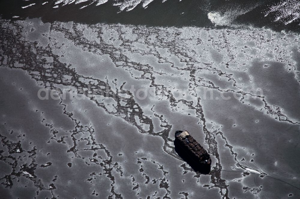 Aerial photograph Sylt - Freight ship on the south coast of the island Sylt in the state of Schleswig-Holstein. The ship is moving through low tide areas of the South Coast in the North Sea. Surrounded by the Wadden Sea, this part of the island is quite dry during the tide and is part of the national park and nature preserve Schleswig-Holsteinsches Wattenmeer