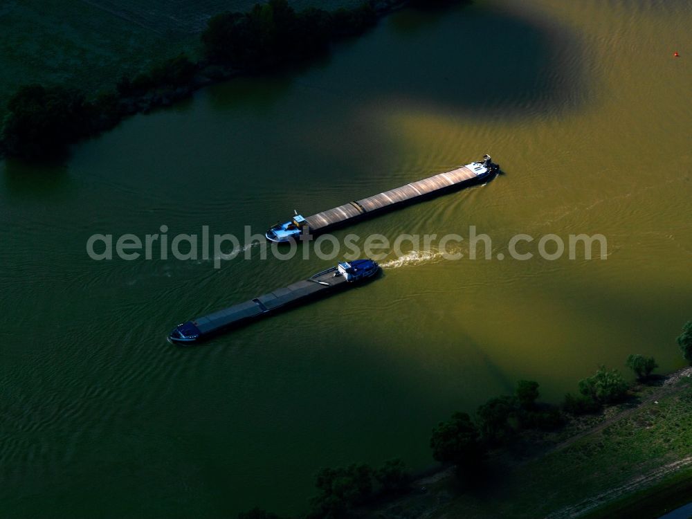 Aerial image Barbing - Freight ships on the Danube in Barbing in the state of Bavaria. The push and container boats are running up and down the Danube the whole year. Here, two can be seen in the transition of light and shadows which lights the river's green water