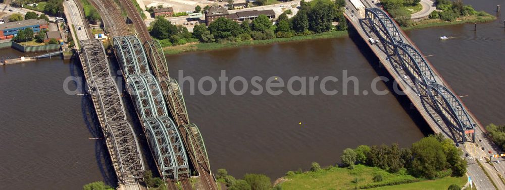 Hamburg from above - Blick auf die Freihafen-Elbrücke, Eisenbahnbrücken und die Neue Elbbrücke (v.l.n.r.). Die Freihafen-Elbbrücke wurde 1929 fertig gestellt, da für den Freihafen eine baulich getrennte Querung der Elbe auch für den Straßenverkehr notwendig war. Die Neue Elbbrücke (rechts) ist die 1990 gebaute erweiterung der Elbbrücke. Die Brücken sind von großer Bedeutung für die Hansestadt, da sie die Verkehrsanbindung Hamburgs über die Elbe gewährleisten. View of the Freihafen-Elbrücke, railway bridges and the Neue Elbbrücke (left to right). The Freihafen-Elbrücke was completed in 1929, because the free port required a structually separated crossing of the Elbe. The new bridge over the Elbe (on the right) is the 1990-built extension to the old bridge over the Elbe. The bridges are of great importance for the Hanseatic city, as they ensure the transport and traffic connection of Hamburg on the Elbe.