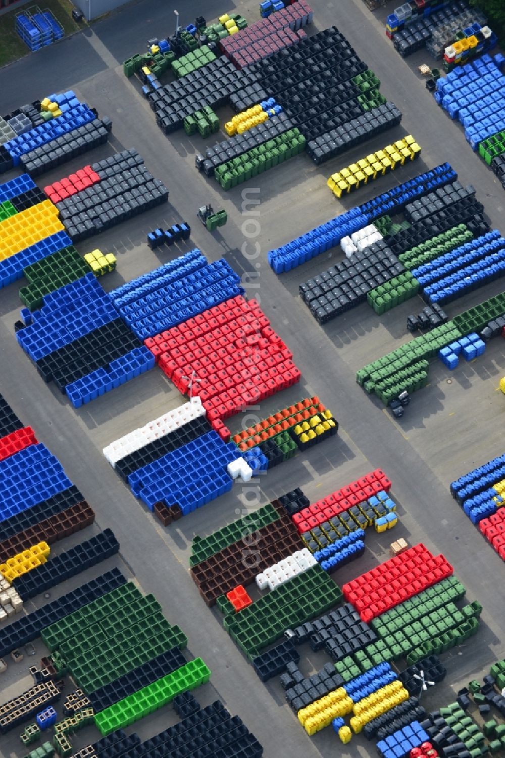 Neuruppin from the bird's eye view: Free storage space colorful plastic tonnes in production facilities of Otto Disposal Systems in Neuruppin in Brandenburg