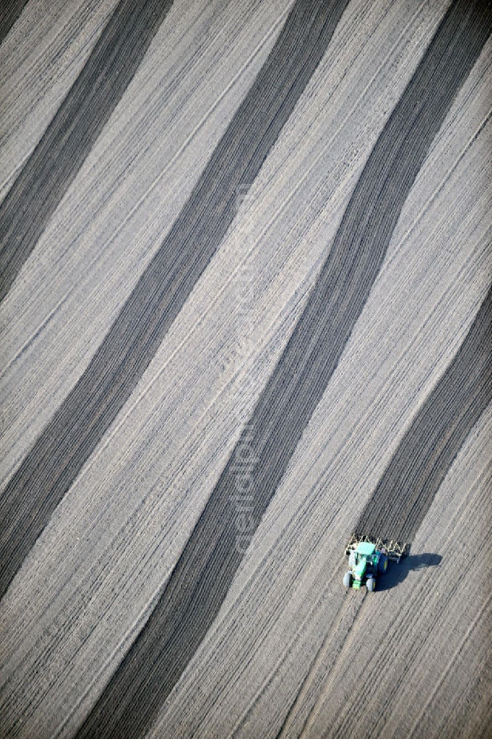 Aerial image Großbrembach - A tractor pulls a plow with his tracks on a field near Großbrembach