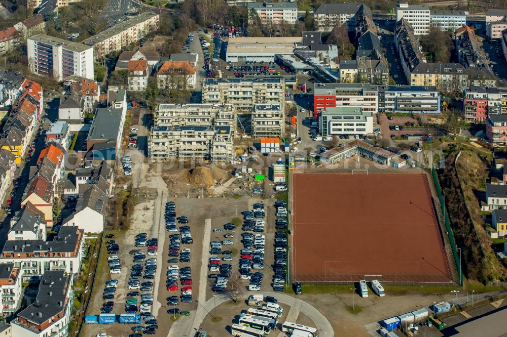 Essen from the bird's eye view: Football pitch and construction site of a new multi-family residential complex on Veronikastrasse in the Ruettenschied part of Essen in the state of North Rhine-Westphalia