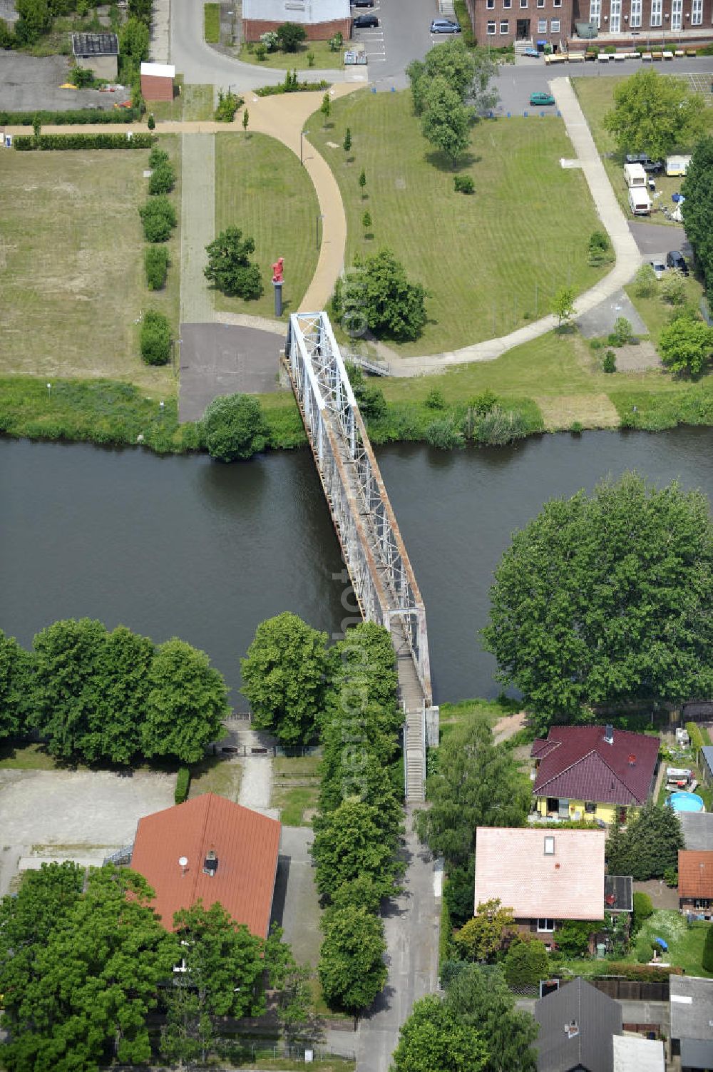 Genthin from above - Blick auf die Genthiner Fußwegbrücke, auch Henkelbrücke genannt. Die Brücke wurde im Jahr 1935 erbaut und überführt den Elbe-Havel-Kanal bei km 363,134. Das Bauwerk führt einen Radweg und Gehweg über den Kanal. Geplant ist hier ein Neubau in Fachwerkbauweise mit schifffahrtstauglicher Höhe über dem Wasserspiegel im Jahr 2011. Ein Projekt des WSV: Wasserstraßen-Neubauamt Magdeburg, 39106 Magdeburg, Tel. +49(0)391 535-0, email: wna-magdeburg@wsv.bund.de The footbridge / skyway in Genthin over the Elbe-Havel-Canal.