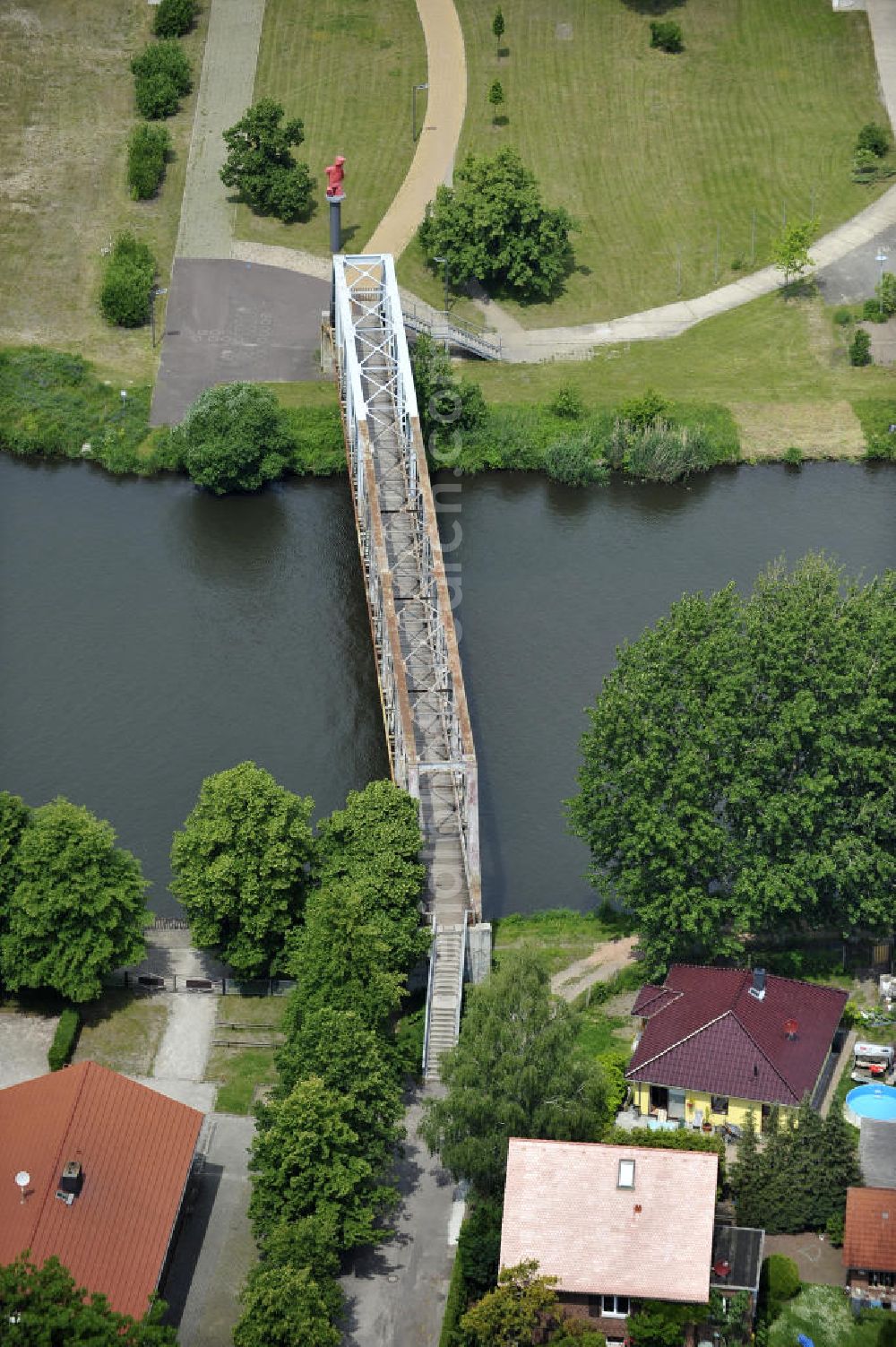 Genthin from the bird's eye view: Blick auf die Genthiner Fußwegbrücke, auch Henkelbrücke genannt. Die Brücke wurde im Jahr 1935 erbaut und überführt den Elbe-Havel-Kanal bei km 363,134. Das Bauwerk führt einen Radweg und Gehweg über den Kanal. Geplant ist hier ein Neubau in Fachwerkbauweise mit schifffahrtstauglicher Höhe über dem Wasserspiegel im Jahr 2011. Ein Projekt des WSV: Wasserstraßen-Neubauamt Magdeburg, 39106 Magdeburg, Tel. +49(0)391 535-0, email: wna-magdeburg@wsv.bund.de The footbridge / skyway in Genthin over the Elbe-Havel-Canal.