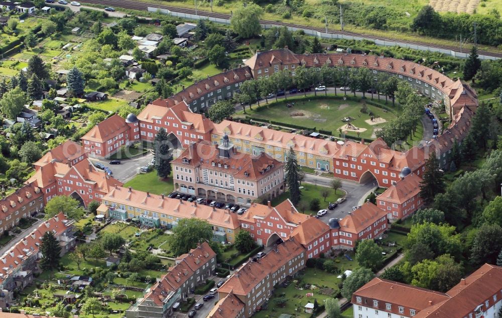 Gotha from the bird's eye view: Meinten Sie: Die Wohnbebauung um den Friedensplatz und den Geschwister-Scholl-Platz in Gotha im Bundesland Thüringen gehört zur Genossenschaftssiedlung der Gothaer Baugenossenschaft für Beamte und Arbeiter der Eisenbahnerverwaltung mit Namen Am schmalen Rain. Errichtet wurden die Mehrfamilienhäuser nach Entwürfen der Architekten Richard Neuland und Bruno Tamme. Ziel des Projektes war es trotz der zur Bauzeit herrschenden Wohnungsnot bezahlbaren und lebenswerten Wohnraum zu schaffen. Wichtiger Teil des Konzeptes sind die zu den Wohnungen gehörenden Kleingärten