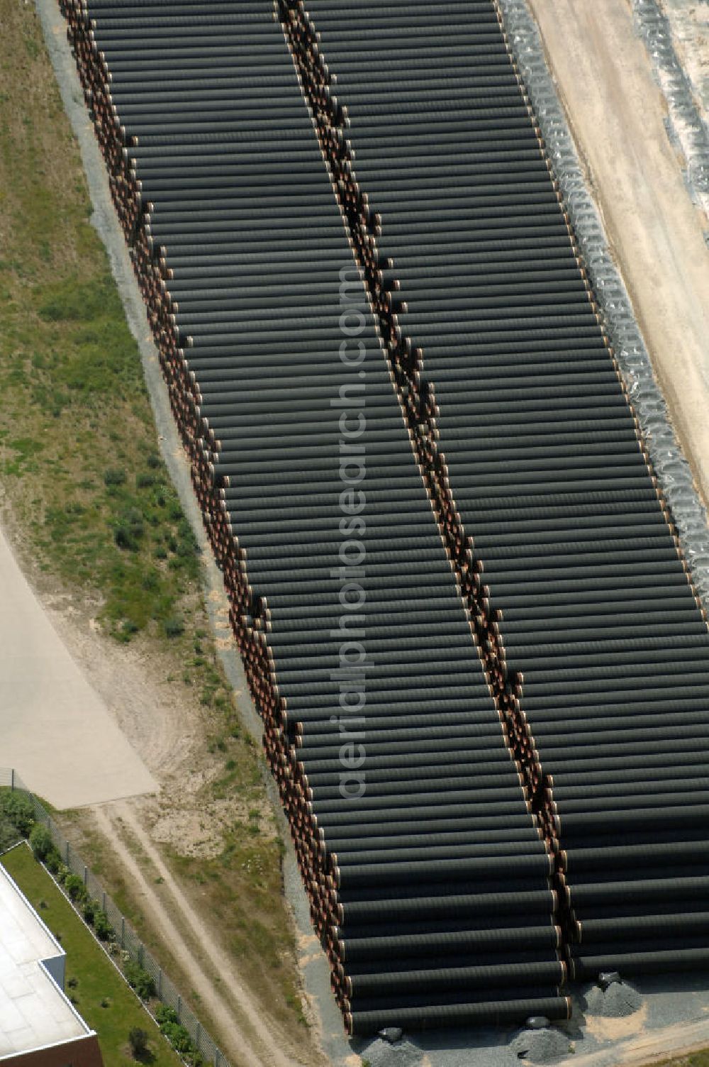 MUKRAN from the bird's eye view: Blick auf die Lagerflächen für die angelieferten Gasleitungsrohre zur geplanten Ostseeleitung auf dem Gelände des Fährhafen Mukran bei Saßnitz auf der Insel Rügen. In den nächsten Monaten sollen insgesamt rund 65 000 Gasleitungssegmente per Bahn nach Mukran geliefert und dort auf mehreren Freiflächen deponiert werden. Im Hafengelände wird derzeit ein neues Werk der nordfranzösischen Firma EUPEC errichtet, in dem die 12,20 Meter langen Rohrsegmente vor ihrer Verlegung in der Ostsee mit Schwerbeton ummantelt werden sollen. Die 1220 Kilometer lange Gastrasse der Nord Stream AG soll voraussichtlich 2010 mit Spezialschiffen vom russischen Vyborg nach Lubmin verlegt werden. Künftig sollen jährlich bis zu 55 Milliarden Kubikmeter Erdgas durch die geplanten beiden Leitungsstränge nach Europa fließen.