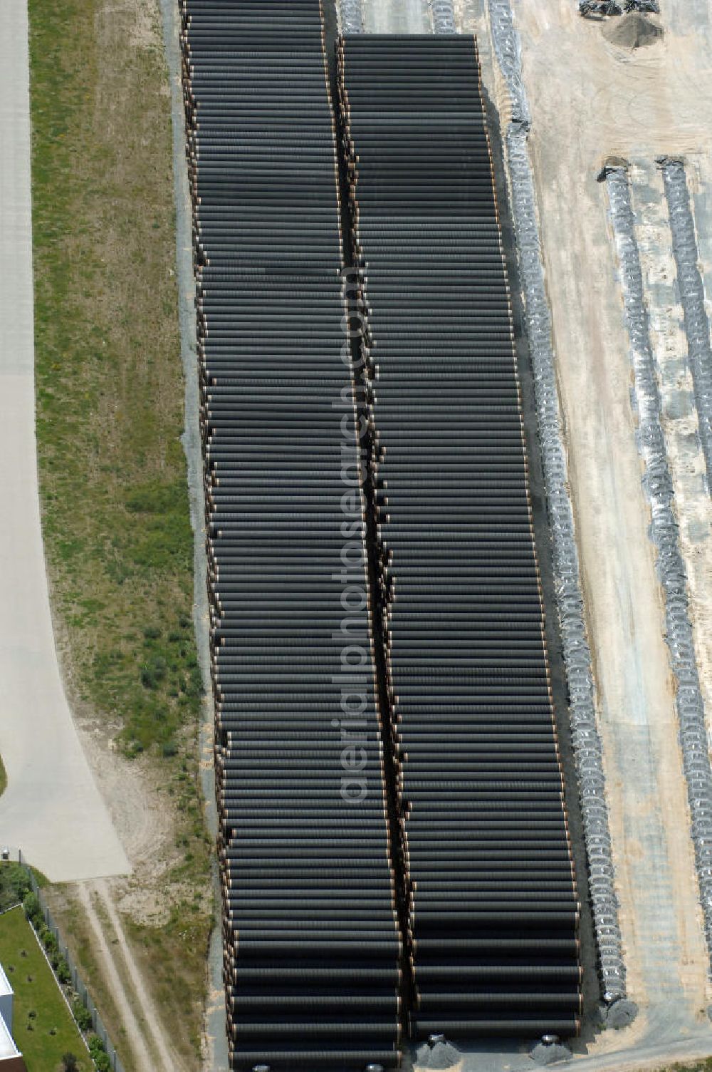 Aerial image MUKRAN - Blick auf die Lagerflächen für die angelieferten Gasleitungsrohre zur geplanten Ostseeleitung auf dem Gelände des Fährhafen Mukran bei Saßnitz auf der Insel Rügen. In den nächsten Monaten sollen insgesamt rund 65 000 Gasleitungssegmente per Bahn nach Mukran geliefert und dort auf mehreren Freiflächen deponiert werden. Im Hafengelände wird derzeit ein neues Werk der nordfranzösischen Firma EUPEC errichtet, in dem die 12,20 Meter langen Rohrsegmente vor ihrer Verlegung in der Ostsee mit Schwerbeton ummantelt werden sollen. Die 1220 Kilometer lange Gastrasse der Nord Stream AG soll voraussichtlich 2010 mit Spezialschiffen vom russischen Vyborg nach Lubmin verlegt werden. Künftig sollen jährlich bis zu 55 Milliarden Kubikmeter Erdgas durch die geplanten beiden Leitungsstränge nach Europa fließen.