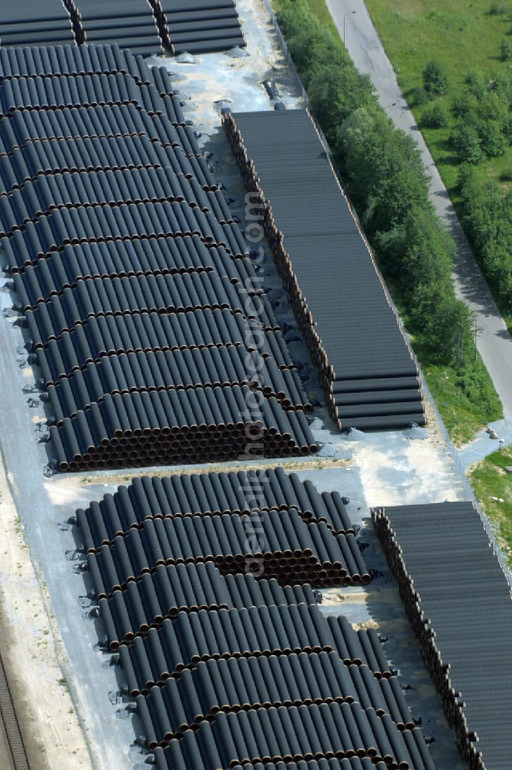 Aerial photograph MUKRAN - Blick auf die Lagerflächen für die angelieferten Gasleitungsrohre zur geplanten Ostseeleitung auf dem Gelände des Fährhafen Mukran bei Saßnitz auf der Insel Rügen. In den nächsten Monaten sollen insgesamt rund 65 000 Gasleitungssegmente per Bahn nach Mukran geliefert und dort auf mehreren Freiflächen deponiert werden. Im Hafengelände wird derzeit ein neues Werk der nordfranzösischen Firma EUPEC errichtet, in dem die 12,20 Meter langen Rohrsegmente vor ihrer Verlegung in der Ostsee mit Schwerbeton ummantelt werden sollen. Die 1220 Kilometer lange Gastrasse der Nord Stream AG soll voraussichtlich 2010 mit Spezialschiffen vom russischen Vyborg nach Lubmin verlegt werden. Künftig sollen jährlich bis zu 55 Milliarden Kubikmeter Erdgas durch die geplanten beiden Leitungsstränge nach Europa fließen.