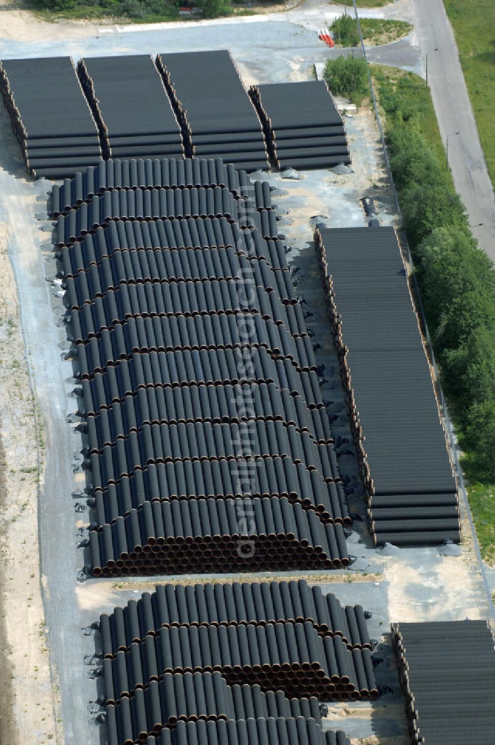 MUKRAN from the bird's eye view: Blick auf die Lagerflächen für die angelieferten Gasleitungsrohre zur geplanten Ostseeleitung auf dem Gelände des Fährhafen Mukran bei Saßnitz auf der Insel Rügen. In den nächsten Monaten sollen insgesamt rund 65 000 Gasleitungssegmente per Bahn nach Mukran geliefert und dort auf mehreren Freiflächen deponiert werden. Im Hafengelände wird derzeit ein neues Werk der nordfranzösischen Firma EUPEC errichtet, in dem die 12,20 Meter langen Rohrsegmente vor ihrer Verlegung in der Ostsee mit Schwerbeton ummantelt werden sollen. Die 1220 Kilometer lange Gastrasse der Nord Stream AG soll voraussichtlich 2010 mit Spezialschiffen vom russischen Vyborg nach Lubmin verlegt werden. Künftig sollen jährlich bis zu 55 Milliarden Kubikmeter Erdgas durch die geplanten beiden Leitungsstränge nach Europa fließen.