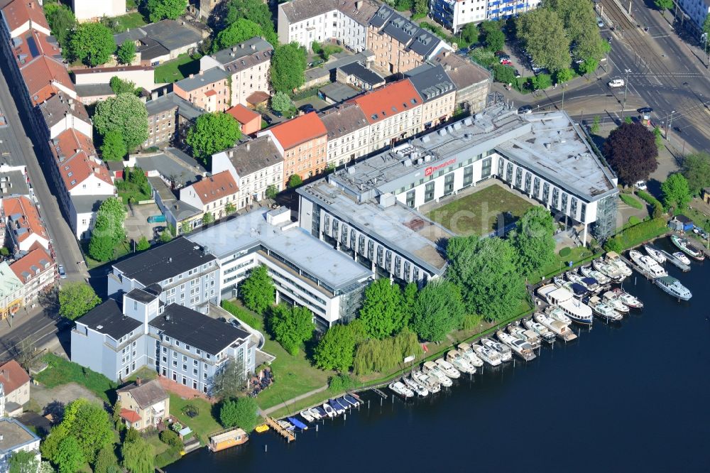 Berlin from above - Buildings and boat docks on Dahme river in the Koepenick part of Berlin in Germany. The elaborate complex on the riverbank includes hotels, health care facilities and a boat school. Koellnischer Platz is located behind it