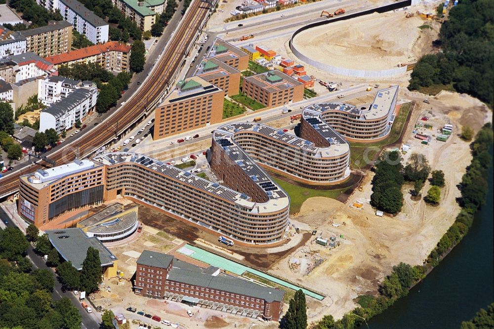 Aerial image Berlin - Where once near the center of Berlin-Mitte was a freight station, at the end of the 90 years an urban residential area for Members of the Bundestag and Federal officials developed. Strikingly, the Serpentine called Residential building with the curve-like floor plan and the atrium houses along the S-Bahn tracks. In the foreground was built from an old shipping building a primary school. Under Construction at this time the Chancellor Park