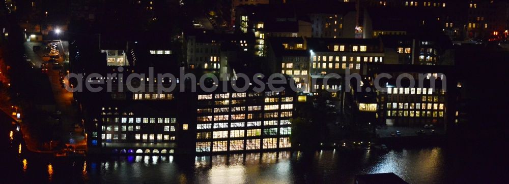 Berlin from above - Night image with a view over the building of the ORCO Property Group in the yard of the GSG Gewerbesiedlungs-Gesellschaft at the riverside of the Spree in the district Friedrichshain-Kreuzberg in Berlin