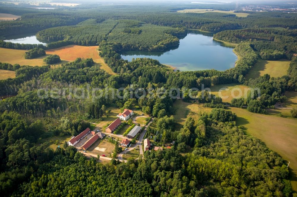 Aerial image Neu-Drosedow - Buildings and park of the farmhouse mansion Gut Drosedow in Neu-Drosedow in the state of Mecklenburg - Western Pomerania. Lake Peetschsee is located in the background, surrounded by forest