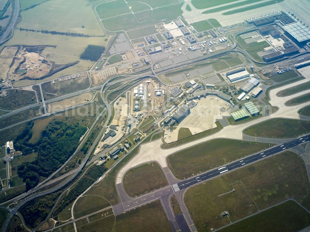 Schönefeld from the bird's eye view: Several buildings and terminals on the premises of the airport Berlin Brandenburg Willy Brandt BER along the Schoenefelder Allee in Schoenefeld in the state of Brandenburg. Airplanes and the Northern runway are visible