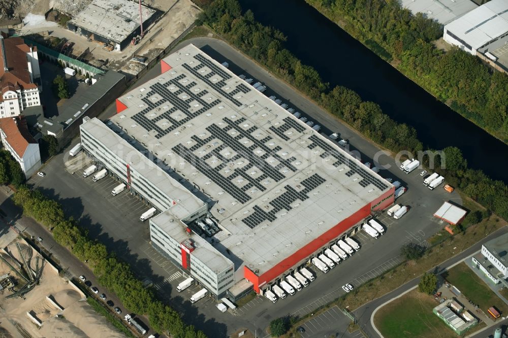 Berlin from the bird's eye view: Premises and building of the cargo and logistics center of the food and grocery store Transgourmet Deutschland in the Tempelhof part of Berlin. The center is located on Saalburgstrasse in the East of Tempelhof, on the riverbank of Teltowkanal