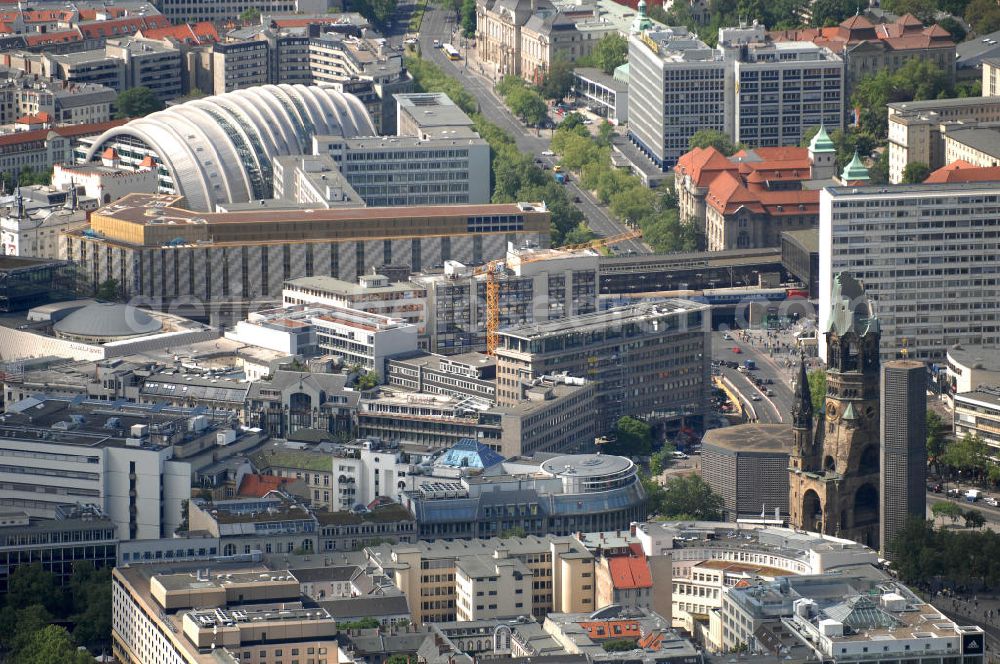 Aerial image Berlin - Blick auf die Gedächtniskirche am Breitscheidplatz. Der Breitscheidplatz liegt in Charlottenburg im Berliner Bezirk Charlottenburg-Wilmersdorf zwischen Kurfürstendamm und Budapester Straße (City West). Östlich schließt sich das Europa-Center an, ungefähr auf der Mitte steht die Kaiser-Wilhelm-Gedächtniskirche und zwischen beiden befindet sich der Weltkugelbrunnen. Westlich wird der Platz durch den Gebäuderiegel des sogenannten „Schimmelpfeng-Hauses“ und die darunter verlaufende Kantstraße begrenzt.