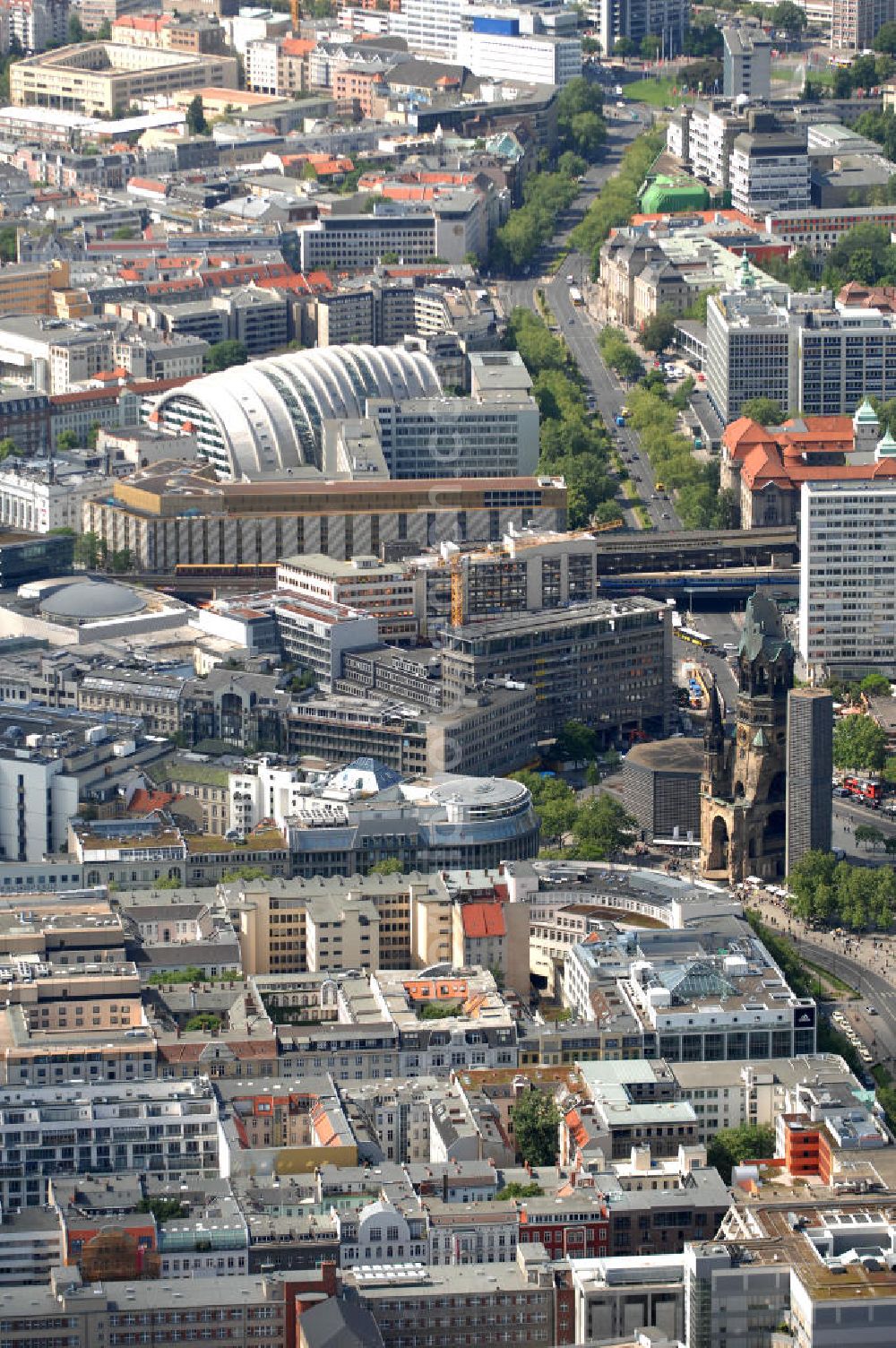 Berlin from the bird's eye view: Blick auf die Gedächtniskirche am Breitscheidplatz. Der Breitscheidplatz liegt in Charlottenburg im Berliner Bezirk Charlottenburg-Wilmersdorf zwischen Kurfürstendamm und Budapester Straße (City West). Östlich schließt sich das Europa-Center an, ungefähr auf der Mitte steht die Kaiser-Wilhelm-Gedächtniskirche und zwischen beiden befindet sich der Weltkugelbrunnen. Westlich wird der Platz durch den Gebäuderiegel des sogenannten „Schimmelpfeng-Hauses“ und die darunter verlaufende Kantstraße begrenzt.