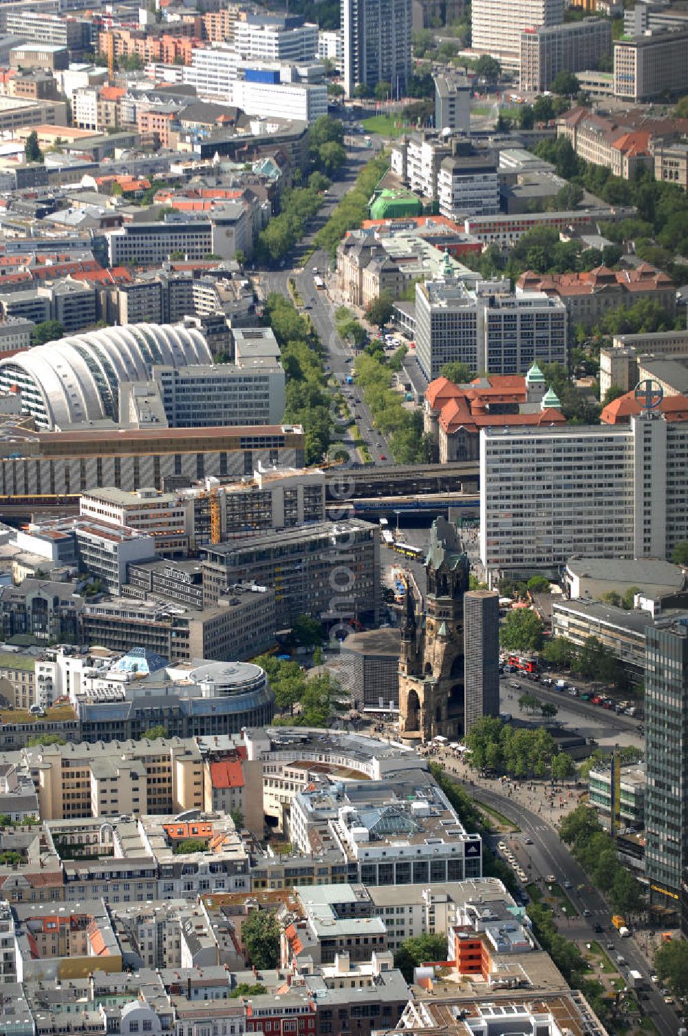 Aerial image Berlin - Blick auf die Gedächtniskirche am Breitscheidplatz. Der Breitscheidplatz liegt in Charlottenburg im Berliner Bezirk Charlottenburg-Wilmersdorf zwischen Kurfürstendamm und Budapester Straße (City West). Östlich schließt sich das Europa-Center an, ungefähr auf der Mitte steht die Kaiser-Wilhelm-Gedächtniskirche und zwischen beiden befindet sich der Weltkugelbrunnen. Westlich wird der Platz durch den Gebäuderiegel des sogenannten „Schimmelpfeng-Hauses“ und die darunter verlaufende Kantstraße begrenzt.