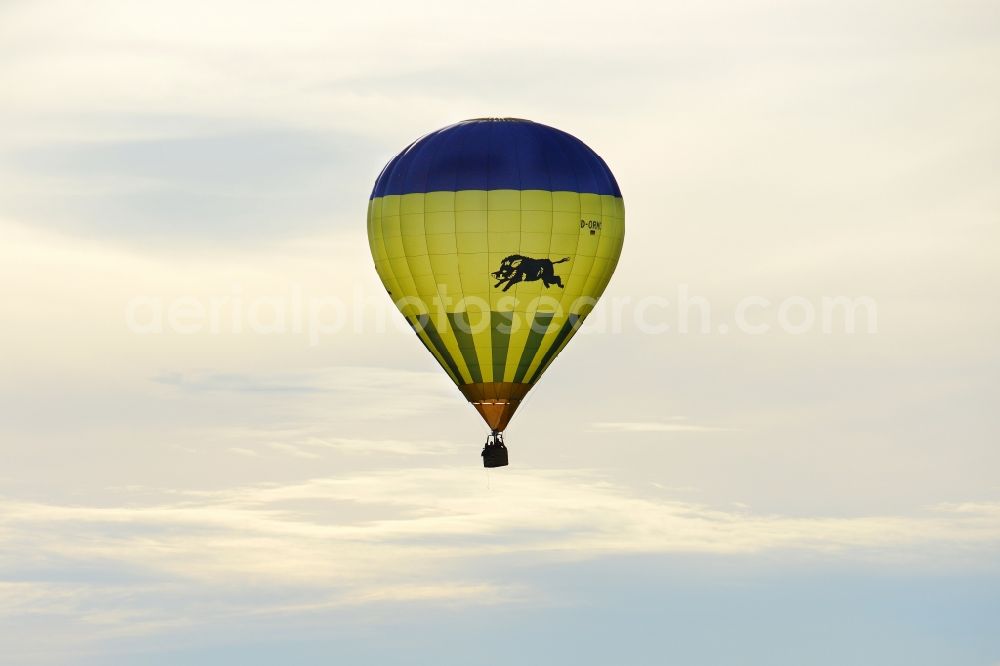 Jork from above - A yellow- blue coloured hot-air balloon with the identifier D-ORMC in flight above Jork in the state Lower Saxony