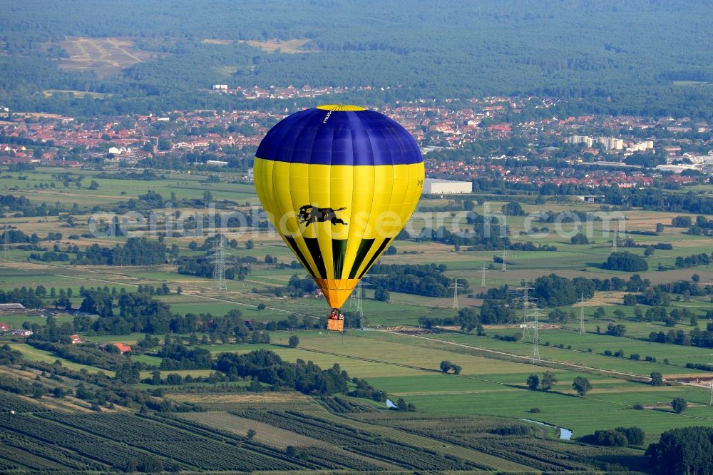 Aerial image Jork - A yellow- blue coloured hot-air balloon with the identifier D-ORMC in flight above Jork in the state Lower Saxony