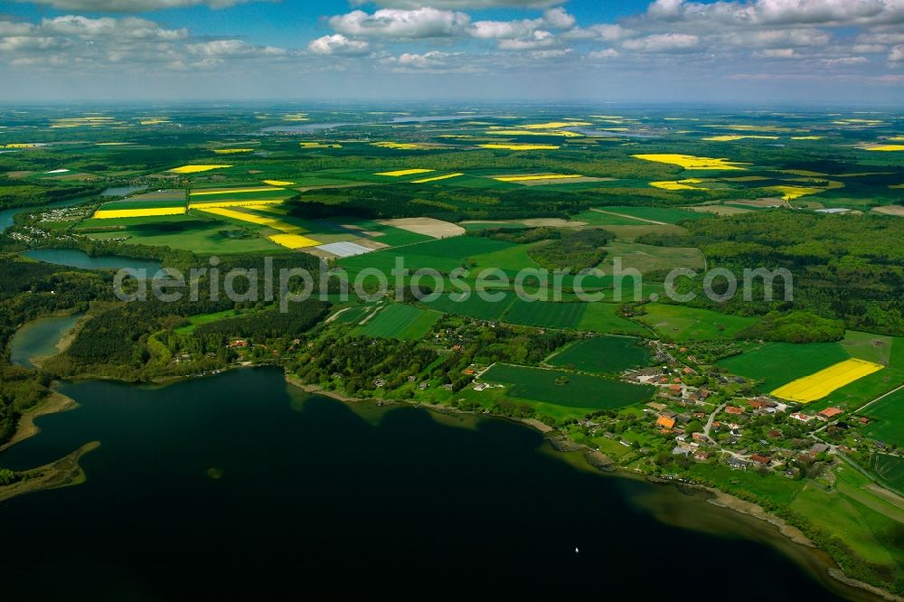 Aerial photograph Dargow - Yellow - green contrast of blooming rapeseed flowers on field stripes in Dargow on the Schaalsee in the state Schleswig-Holstein, Germany