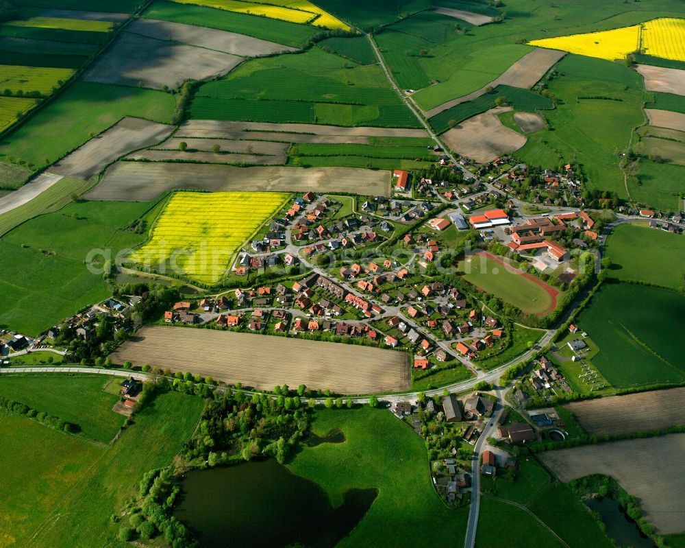 Sandesneben from the bird's eye view: Yellow - green contrast of blooming rapeseed flowers on field stripes in Sandesneben in the state Schleswig-Holstein, Germany