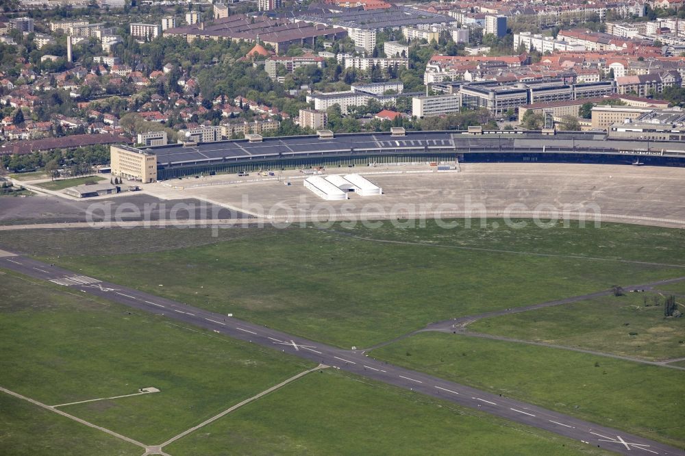 Aerial photograph Berlin - Premises of the former airport Berlin-Tempelhof Tempelhofer Freiheit in the Tempelhof part of Berlin, Germany. The premises include the historic main building and radar tower as well as two runways. Its hangars are partly used as refugee and asylum seekers accommodations