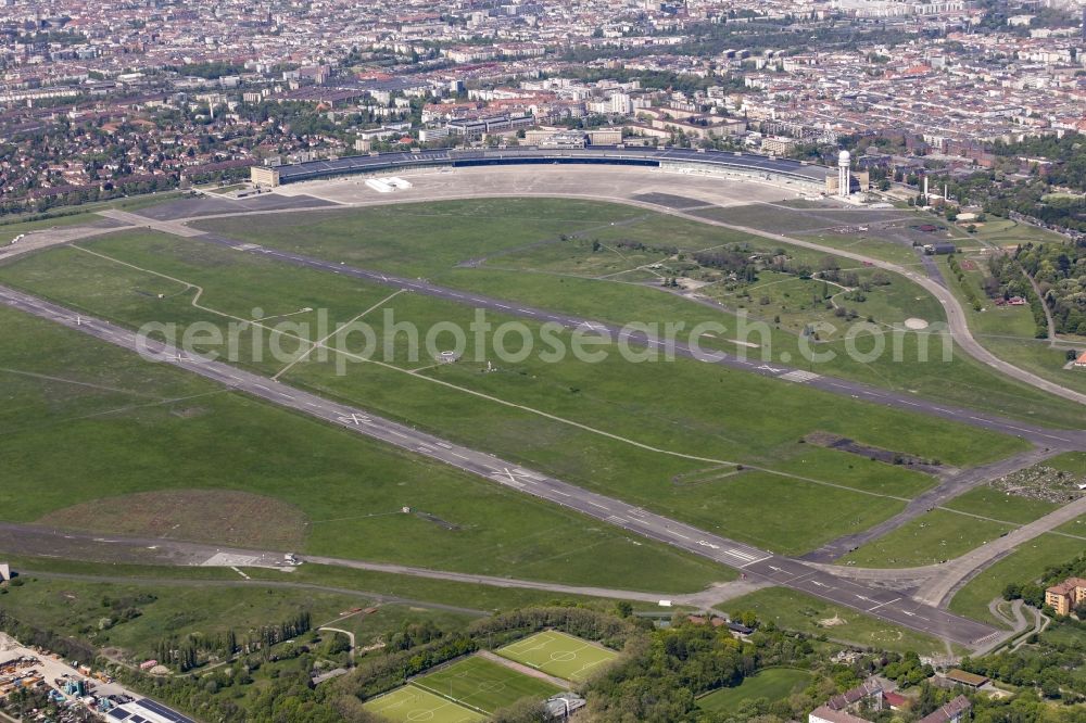 Berlin from above - Premises of the former airport Berlin-Tempelhof Tempelhofer Freiheit in the Tempelhof part of Berlin, Germany. The premises include the historic main building and radar tower as well as two runways. Its hangars are partly used as refugee and asylum seekers accommodations