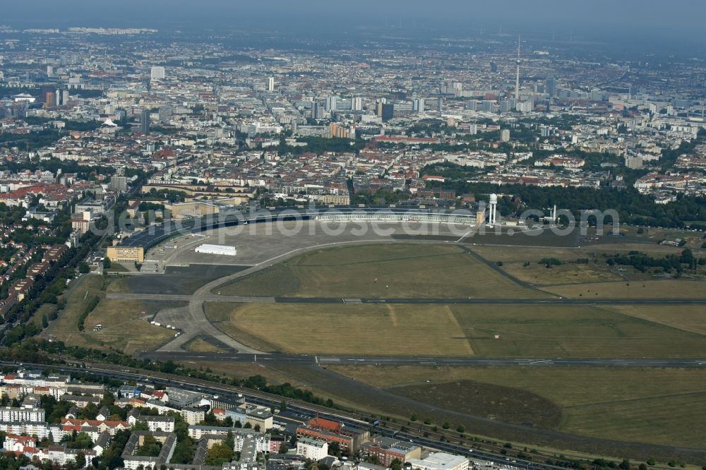 Aerial photograph Berlin - Premises of the former airport Berlin-Tempelhof Tempelhofer Freiheit in the Tempelhof part of Berlin, Germany. The premises include the historic main building and radar tower as well as two runways. Its hangars are partly used as refugee and asylum seekers accommodations