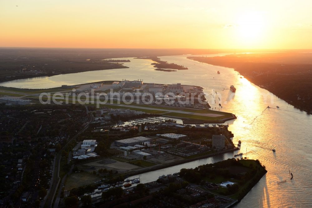 Aerial image Hamburg - Runway with hangar taxiways and terminals on the grounds of the airport Hamburg Finkenwerder Airport in Hamburg at sunrise