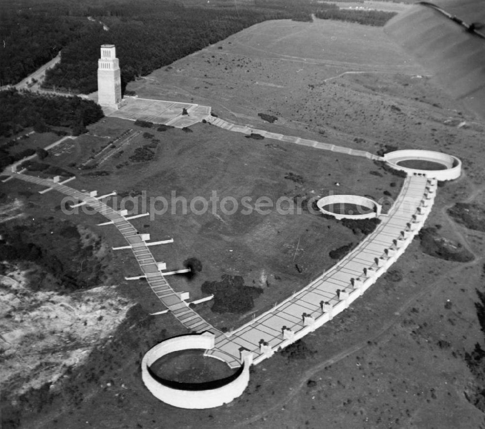 Buchenwald bei Weimar from above - Blick auf das Gelände am Glockenturm ,dem Mahnmal auf dem Gelände des ehem. Konzentrationslagers KL Buchenwald. Das Mahnmal wurde in der Zeit von 1954 bis 1958 gebaut. Der Konzeption liegt das Motto „Durch Sterben und Kämpfen zum Sieg“ zu Grunde. Der Besucher soll dabei weg vom Tod ins Leben gewiesen werden. Die gesamte monumentale Anlage ist in der Form dem Sozialistischen Realismus zuzuordnen. Vom Eingangstor führt eine Treppe hangabwärts. Die Treppe wird von 7 Stelen flankiert, die symbolisch für die sieben Existenzjahre des Konzentrationslager stehen. Die Stelen wurden von den Bildhauern René Graetz, Waldemar Grzimek und Hans Kies entworfen und erstellt. Auf der Rückseite der Stelen stehen Texte von Johannes R. Becher. Am Ende der Treppe befinden sich Grabtrichter. In diesen Erdsenken ließ die SS kurz vor der Befreiung des Konzentrationslagers 1945 etwa 3000 Tote verscharren. Von den Grabtrichtern wurden drei in Form von Ringgräbern zum Bestandteil der Gedenkstätte.