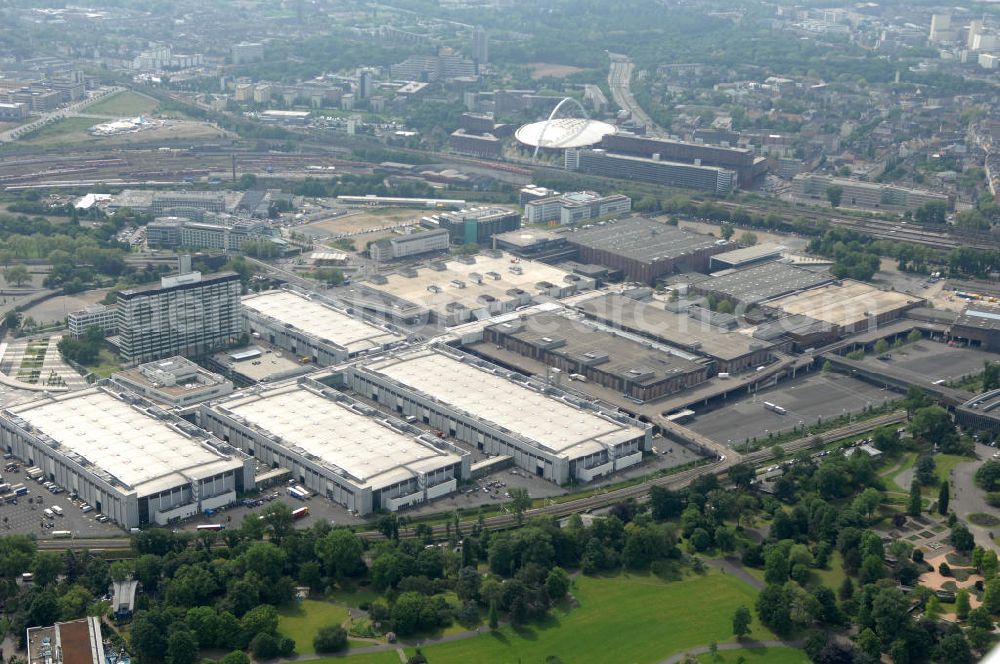 KÖLN from the bird's eye view: Blick auf das Gelände der Kölnmesse östlich des Rheins. Sie ist ein wichtiger Faktor für den Wirtschaft Kölns und den Wirtschaftsstandort Köln. Die Koelnmesse organisiert regelmäßig über 70 Messen im In- und Ausland. 25 davon gelten als die bedeutendsten Messen im jeweiligen Wirtschaftszweig. Somit ist die Koelnmesse größter Veranstalter von Messen auf einem eigenen Gelände und, gemessen an ihrer Ausstellungsfläche, die viert größte Messe weltweit. Jährlich werden rund 2,3 Millionen Besucher aus fast 200 Ländern gezählt. Das Gelände bietet Kapazitäten für Tagungen mit über 19.500 Teilnehmern und den Rahmen für Kongresse mit begleitenden Ausstellungen.