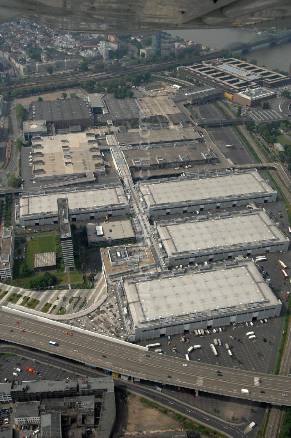 Aerial image KÖLN - Blick auf das Gelände der Kölnmesse östlich des Rheins. Sie ist ein wichtiger Faktor für den Wirtschaft Kölns und den Wirtschaftsstandort Köln. Die Koelnmesse organisiert regelmäßig über 70 Messen im In- und Ausland. 25 davon gelten als die bedeutendsten Messen im jeweiligen Wirtschaftszweig. Somit ist die Koelnmesse größter Veranstalter von Messen auf einem eigenen Gelände und, gemessen an ihrer Ausstellungsfläche, die viert größte Messe weltweit. Jährlich werden rund 2,3 Millionen Besucher aus fast 200 Ländern gezählt. Das Gelände bietet Kapazitäten für Tagungen mit über 19.500 Teilnehmern und den Rahmen für Kongresse mit begleitenden Ausstellungen.