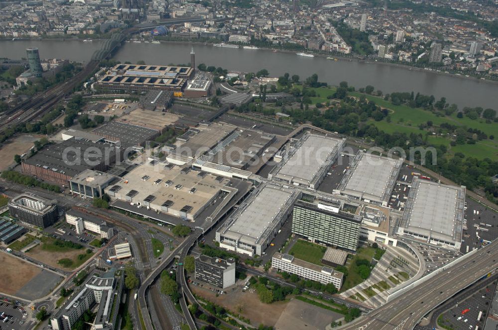 Aerial photograph KÖLN - Blick auf das Gelände der Kölnmesse östlich des Rheins. Sie ist ein wichtiger Faktor für den Wirtschaft Kölns und den Wirtschaftsstandort Köln. Die Koelnmesse organisiert regelmäßig über 70 Messen im In- und Ausland. 25 davon gelten als die bedeutendsten Messen im jeweiligen Wirtschaftszweig. Somit ist die Koelnmesse größter Veranstalter von Messen auf einem eigenen Gelände und, gemessen an ihrer Ausstellungsfläche, die viert größte Messe weltweit. Jährlich werden rund 2,3 Millionen Besucher aus fast 200 Ländern gezählt. Das Gelände bietet Kapazitäten für Tagungen mit über 19.500 Teilnehmern und den Rahmen für Kongresse mit begleitenden Ausstellungen.