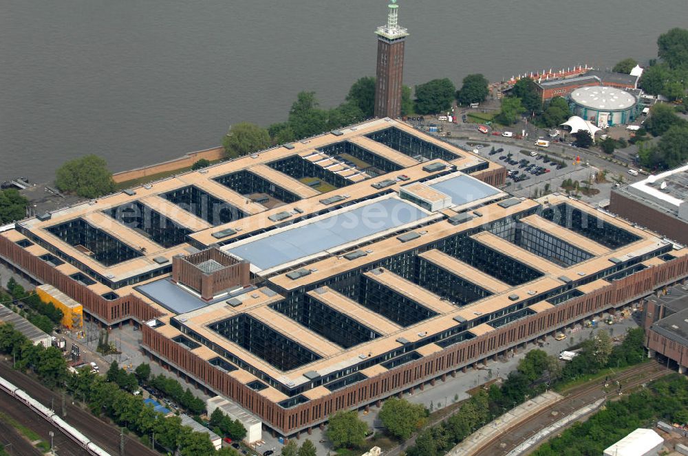 Aerial image KÖLN - Blick auf das Gelände der Kölnmesse östlich des Rheins. Sie ist ein wichtiger Faktor für den Wirtschaft Kölns und den Wirtschaftsstandort Köln. Die Koelnmesse organisiert regelmäßig über 70 Messen im In- und Ausland. 25 davon gelten als die bedeutendsten Messen im jeweiligen Wirtschaftszweig. Somit ist die Koelnmesse größter Veranstalter von Messen auf einem eigenen Gelände und, gemessen an ihrer Ausstellungsfläche, die viert größte Messe weltweit. Jährlich werden rund 2,3 Millionen Besucher aus fast 200 Ländern gezählt. Das Gelände bietet Kapazitäten für Tagungen mit über 19.500 Teilnehmern und den Rahmen für Kongresse mit begleitenden Ausstellungen.