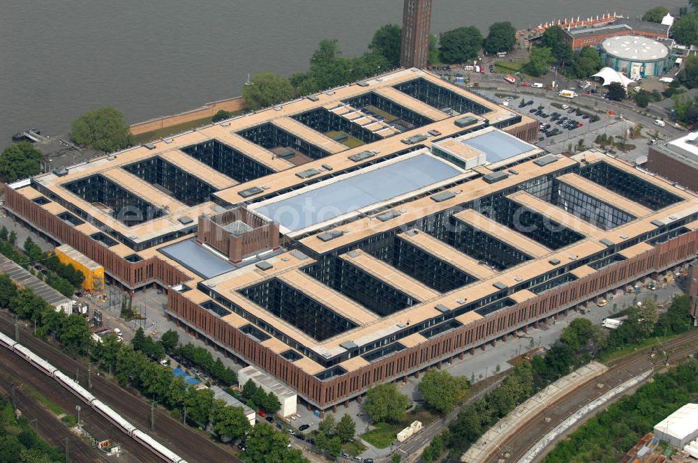 Aerial photograph KÖLN - Blick auf das Gelände der Kölnmesse östlich des Rheins. Sie ist ein wichtiger Faktor für den Wirtschaft Kölns und den Wirtschaftsstandort Köln. Die Koelnmesse organisiert regelmäßig über 70 Messen im In- und Ausland. 25 davon gelten als die bedeutendsten Messen im jeweiligen Wirtschaftszweig. Somit ist die Koelnmesse größter Veranstalter von Messen auf einem eigenen Gelände und, gemessen an ihrer Ausstellungsfläche, die viert größte Messe weltweit. Jährlich werden rund 2,3 Millionen Besucher aus fast 200 Ländern gezählt. Das Gelände bietet Kapazitäten für Tagungen mit über 19.500 Teilnehmern und den Rahmen für Kongresse mit begleitenden Ausstellungen.