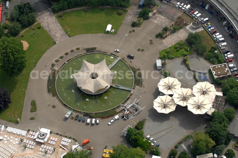 KÖLN from above - Blick auf das Gelände der Kölnmesse östlich des Rheins. Sie ist ein wichtiger Faktor für den Wirtschaft Kölns und den Wirtschaftsstandort Köln. Die Koelnmesse organisiert regelmäßig über 70 Messen im In- und Ausland. 25 davon gelten als die bedeutendsten Messen im jeweiligen Wirtschaftszweig. Somit ist die Koelnmesse größter Veranstalter von Messen auf einem eigenen Gelände und, gemessen an ihrer Ausstellungsfläche, die viert größte Messe weltweit. Jährlich werden rund 2,3 Millionen Besucher aus fast 200 Ländern gezählt. Das Gelände bietet Kapazitäten für Tagungen mit über 19.500 Teilnehmern und den Rahmen für Kongresse mit begleitenden Ausstellungen.