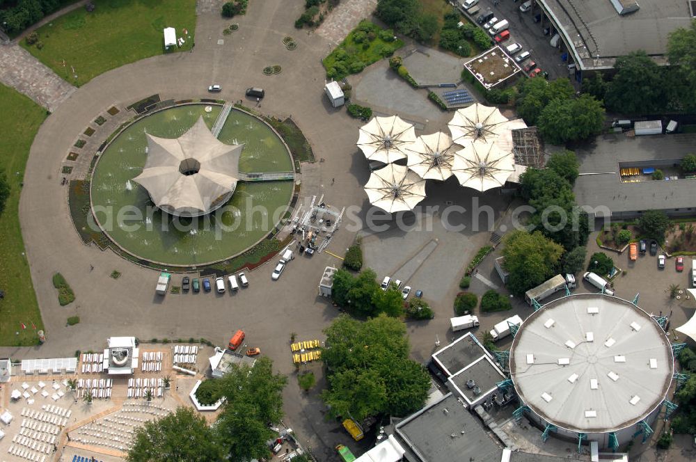 KÖLN from the bird's eye view: Blick auf das Gelände der Kölnmesse östlich des Rheins. Sie ist ein wichtiger Faktor für den Wirtschaft Kölns und den Wirtschaftsstandort Köln. Die Koelnmesse organisiert regelmäßig über 70 Messen im In- und Ausland. 25 davon gelten als die bedeutendsten Messen im jeweiligen Wirtschaftszweig. Somit ist die Koelnmesse größter Veranstalter von Messen auf einem eigenen Gelände und, gemessen an ihrer Ausstellungsfläche, die viert größte Messe weltweit. Jährlich werden rund 2,3 Millionen Besucher aus fast 200 Ländern gezählt. Das Gelände bietet Kapazitäten für Tagungen mit über 19.500 Teilnehmern und den Rahmen für Kongresse mit begleitenden Ausstellungen.