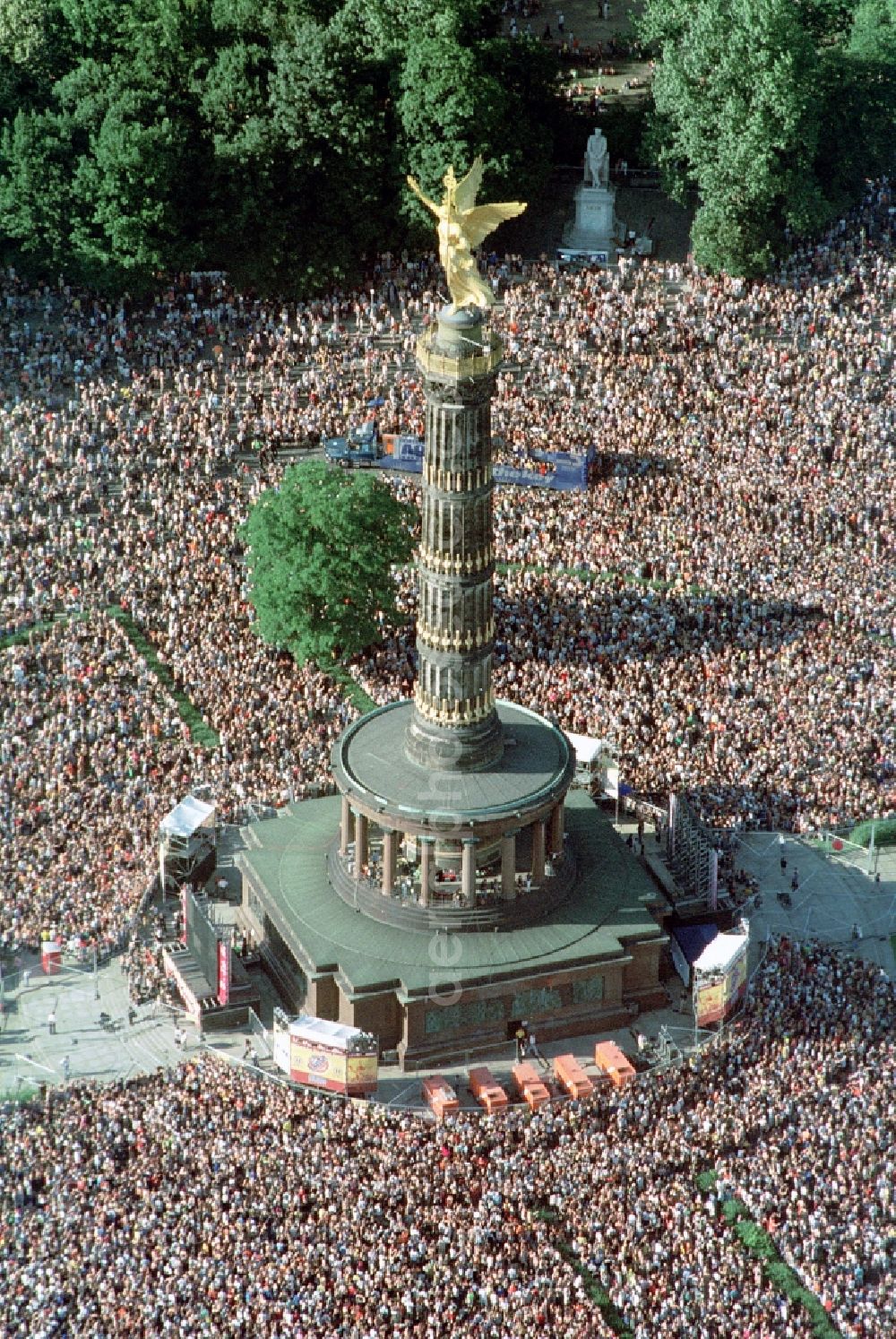 Berlin from above - Participants in the Love Parade music festival on the event concert area on the Great Star at the Victory Column and the Strasse des 17. Juni in the district Tiergarten in Berlin, Germany