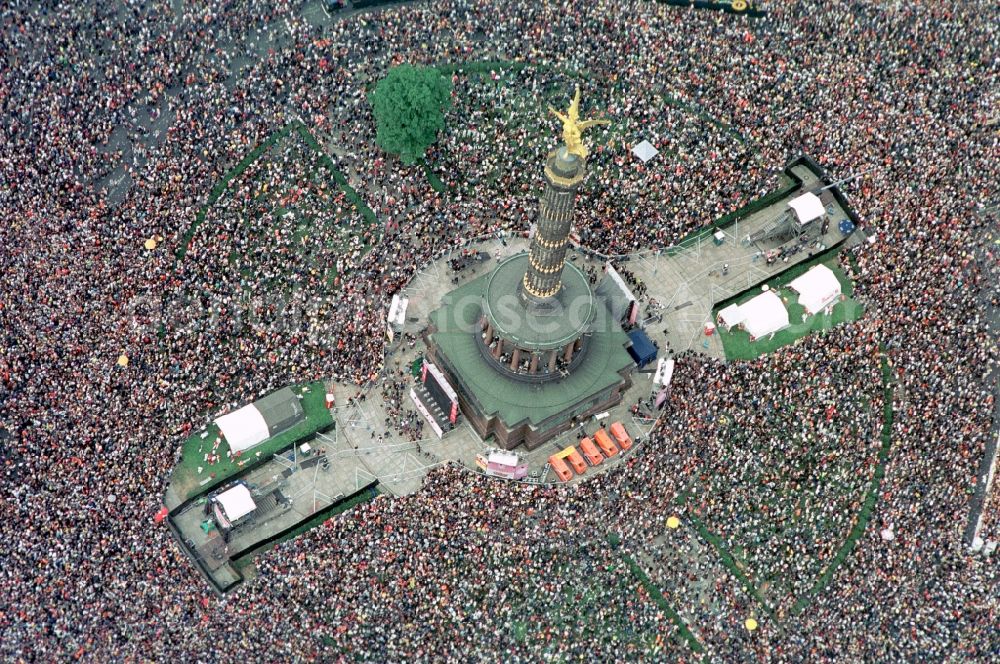 Berlin from the bird's eye view: Participants in the Love Parade music festival on the event concert area on the Great Star at the Victory Column and the Strasse des 17. Juni in the district Tiergarten in Berlin, Germany