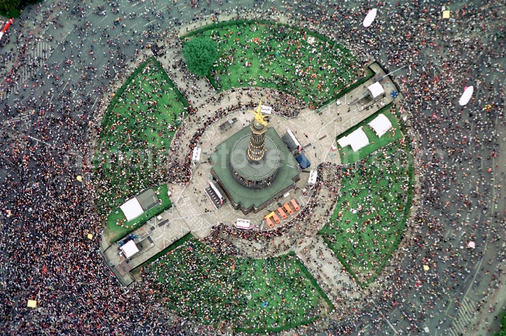 Berlin from the bird's eye view: Participants in the Love Parade music festival on the event concert area on the Great Star at the Victory Column and the Strasse des 17. Juni in the district Tiergarten in Berlin, Germany