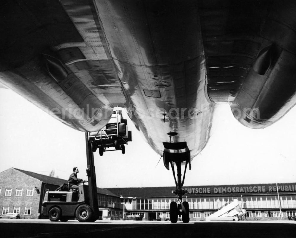 SCHÖNEFELD from the bird's eye view: Gepäckbeladung vor der alten Passagierabfertigung des Flughafen Schönefeld an einer Tupolev TU-104 der AEROLFLOT. Gut erkennt man die beiden Lufteinläufe der Triebwerke im Tragflächenansatz, sowie das hochbeinige Bugfahrwerk.