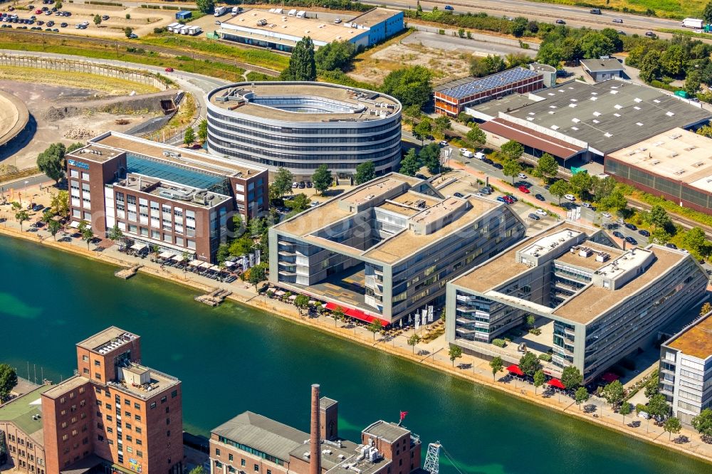 Aerial photograph Duisburg - Industrial estate and company settlement overlooking the Looper designed by the architects Bahl & Partner architects BDA and implemented by the project developer Koebl Kruse GmbH, as well as on the company building of the Volksbank Rhein-Ruhr eG on the shore of the inner harbor along the Schifferstrasse in Duisburg state North Rhine-Westphalia, Germany