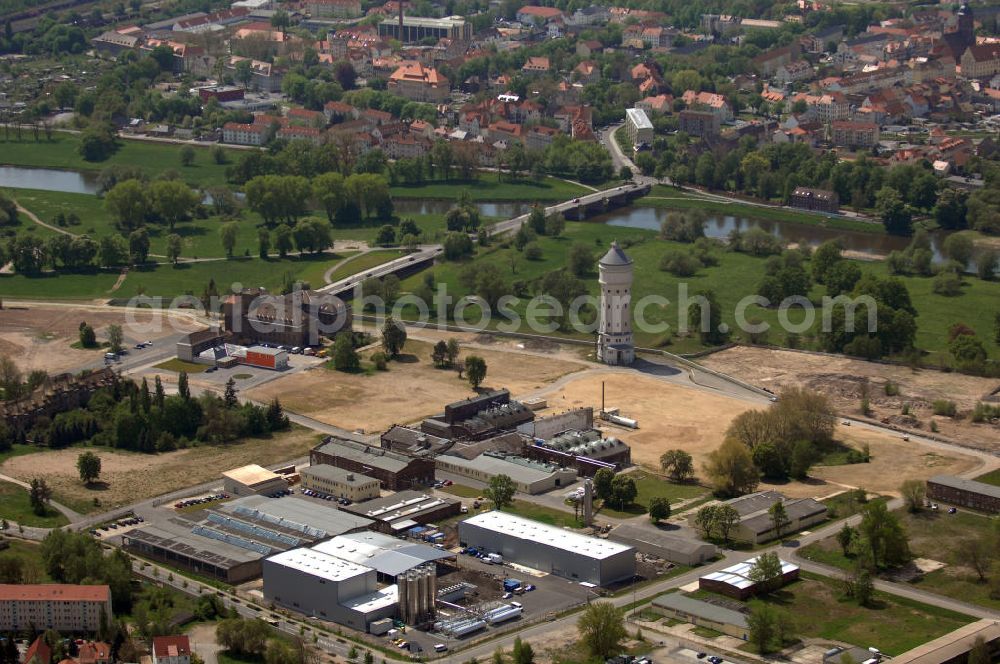 Eilenburg from the bird's eye view: Blick auf das Gewerbegebiet Eilenburg-Ost mit dem Industriewahrzeichen dem ECW-Wasserturm. Zur Zeit werden Fabrikhallen abgerissen und es siedelt sich Kleingewerbe an. Im Hintergrund sieht man einen kleinen Teil von Eilenburg mit der 1999 errichteten Muldebrücke. Kontakt: 04838 Eilenburg, Email: webmaster@eilenburg.de