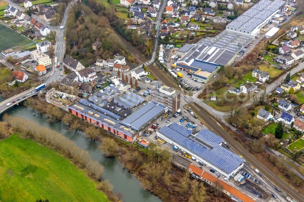 Fröndenberg/Ruhr from the bird's eye view: Industrial estate and company settlement along the Ruhr with a dam and a bridge structure at Unnaer Strasse / Ardeyer Strasse in the district Langschede in Froendenberg/Ruhr in the state North Rhine-Westphalia, Germany