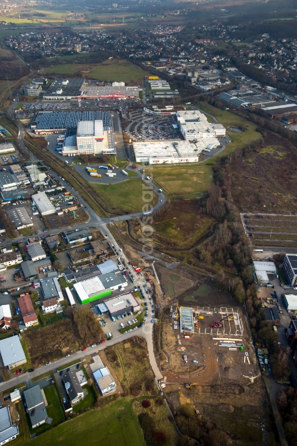 Witten from above - Industrial estate and company settlement with branches of Ostermann and Bauhaus in the East of Witten in the state of North Rhine-Westphalia. A construction site is located in the foreground on Salinger Feld