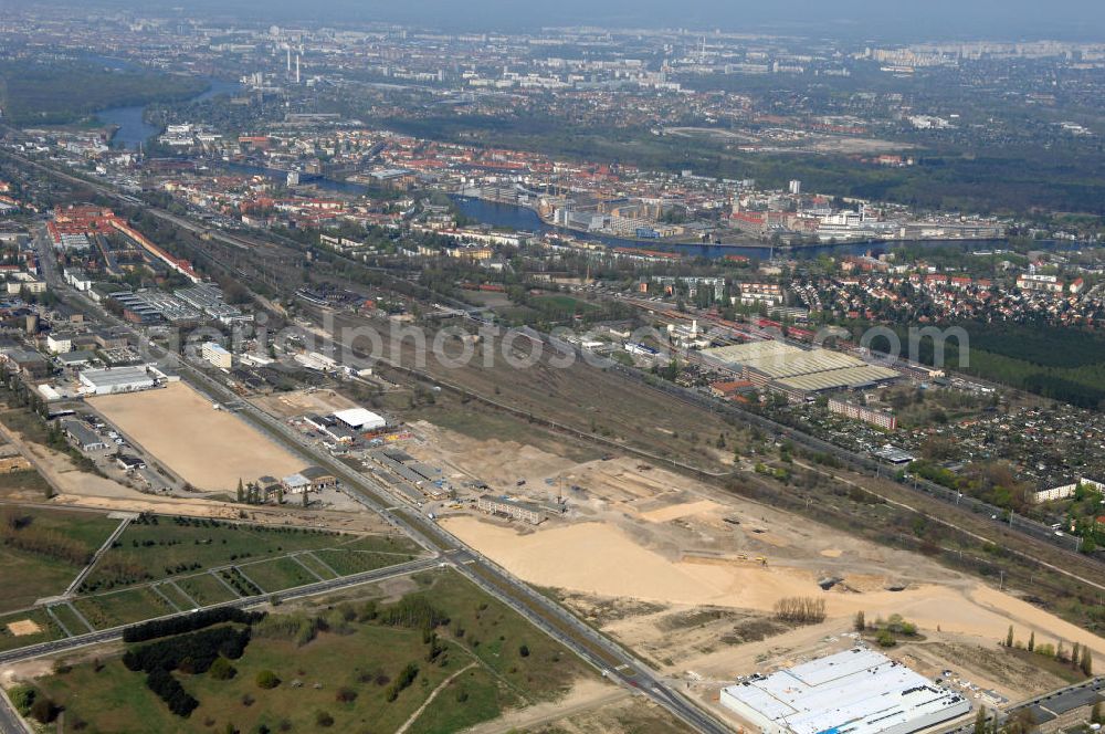 Aerial photograph Berlin - Blick auf eine Planfläche im Gewerbegebiet Flugplatz Johannisthal am Groß-Berliner Damm. Das Gelände dient heute als Baufläche für Einfamilienhäuser und als Gewerbegebiet. Des weiteren befindet sich heute auf dem Gelände unter an derem der Aerodynamische Park als Teil des Campus der Humboldt-Universität zu Berlin. Der Name des Platzes weist auf den besonderen Charakter und die historische wie architektonische Bedeutung durch die prägnanten und dominierenden Baudenkmale der ehemaligen Deutschen Versuchsanstalt für Luftfahrt e.V. hin. Das mittlerweile entstandene grüne Biotop auf der Fläche der ehemaligen Start- und Landebahn ist in eine Parklandschaft integriert worden, dem Europapark, der nach einem Wettbewerb seit den späten 1990er Jahren hier entsteht.